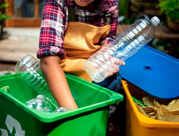 Persona guardando botellas para reciclar